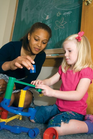 student working with a child using blocks
